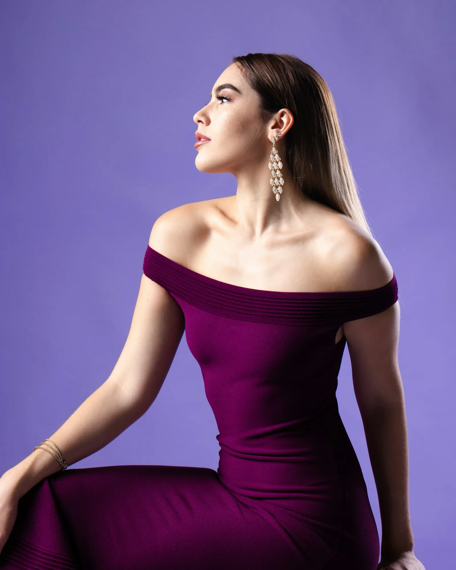 Mujer con blusa morada de hombros descubiertos